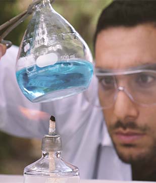 כימאי עם משקפי מגן מול צנצנת מעבדה סרטון תדמית טכניון